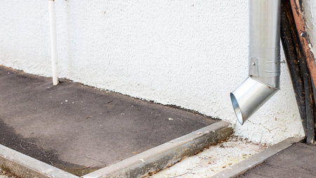 There is a drainpipe that is currently hanging off the side of a building, creating a noticeable...