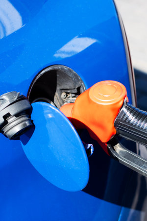 A blue car is currently in the process of being filled with gasoline at the gas station, ready for its upcoming journeyの写真素材