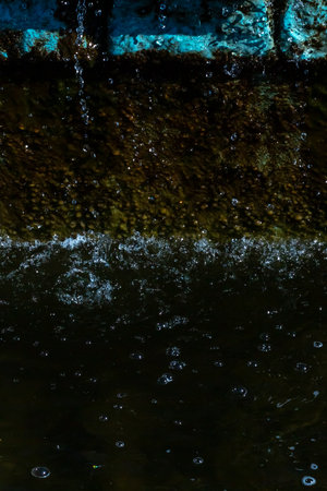 A detailed close up of a splash of water creating ripples in a serene body of water, capturing the...