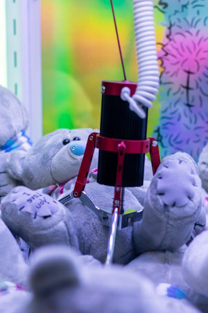 A large group of adorable teddy bears is currently being clawed at by a mechanical machine designed...
