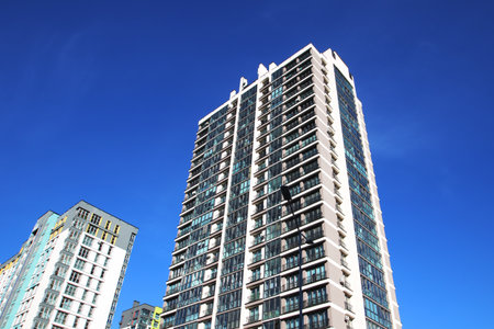 A towering tall building stands prominently with a vivid blue sky serving as the beautiful...