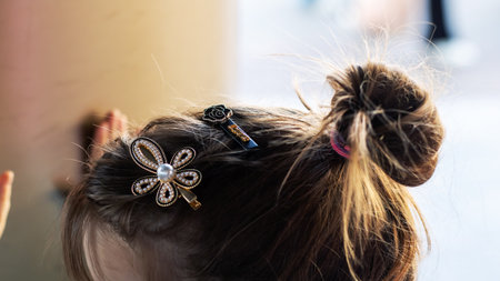 A beautiful woman has a stylish bun with a lovely flower in her hairの写真素材