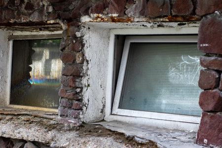 A sturdy brick wall featuring a white window adorned with a white frame that enhances its overall...