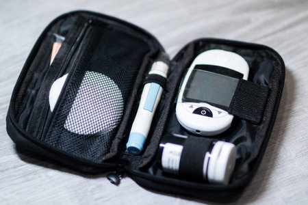 Open diabetes kit showing glucometer lancet and strips, black zippered pouch organized for travel,...