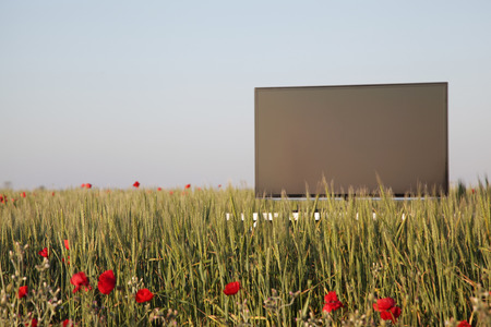 Modern television standing up on a green field in sunlightの写真素材