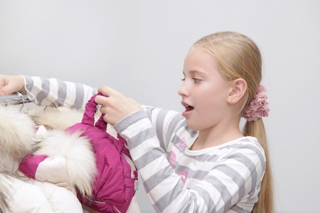 Surprised young little girl in the mall become puzzled seeing many clothesの写真素材