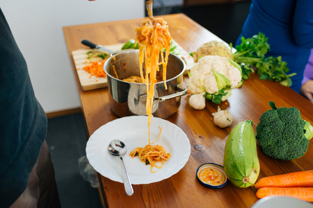 Close View of Woman Preparing a Delicious Spaghetti in The Kitchen. Healthy Food Concept.の写真素材
