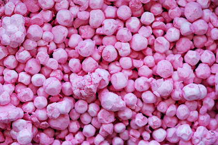 Polystyrene balls colored in pink, forming a background texture that looks like colored stones.の写真素材