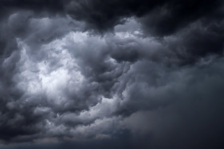Dark, dramatic thunderstorm clouds swirling across the sky, creating an intense and moody...
