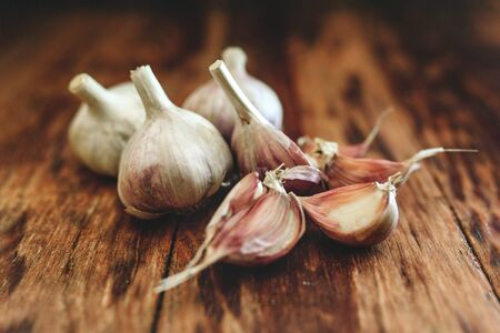 Ripe and raw organic garlic on wooden background, alternative medicine, organic cleaners. Garlics background.の写真素材