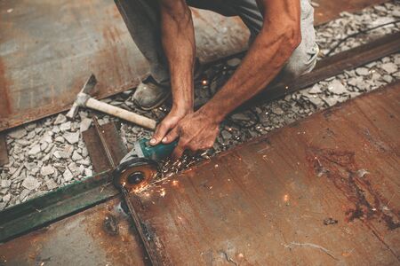 A man cuts metal to make a gate.の写真素材