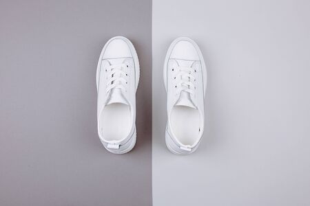 Pair of trendy sneakers on light background, flat lay. Space for text.の写真素材