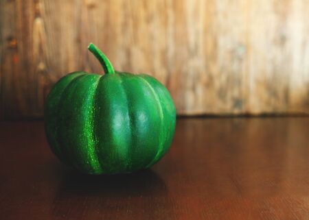 Green pumpkin with stem on dark wooden background, top viewの写真素材
