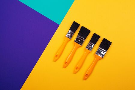 Brush with yellow handle on blue yellow purple background. Main trend concept. Trend colors.の写真素材