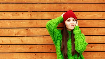 Attractive laughing female standing against wooden wall background with copy space area, pretty casually-dressed hipster woman looking away smiling and feeling so happy in joyの写真素材