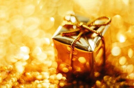 Golden gift on defocused lights background close up.の写真素材