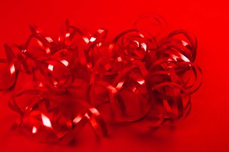 Red ribbon roll on red background. Hollyday and party concept.の写真素材