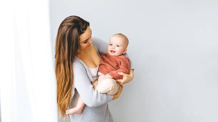 Happy mother holding up her baby girlの写真素材