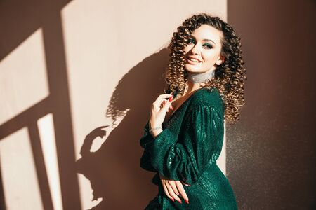 Party and holidays concept. Glamour woman in luxury glitter sequins dress dancing and having fun. Hollywood make up, wavy hairstyle. White background. fashion shiny green dress. Classic blue color of year 2020の写真素材