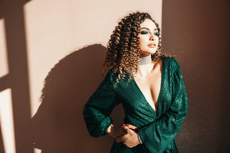 Party and holidays concept. Glamour woman in luxury glitter sequins dress dancing and having fun. Hollywood make up, wavy hairstyle. White background. fashion shiny green dress. Classic blue color of year 2020の写真素材