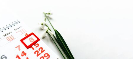 Calendar page with marked date of International Womens Day. snowdrops on a white backgroundの写真素材