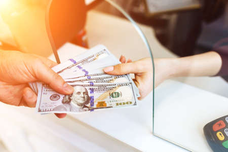 man changes money in a currency exchange, a large sum of dollars, an increase in the exchange rate