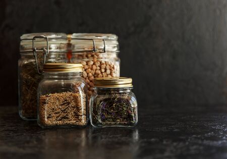 Food set. Raw cereals, pasta, groats, organic legumes and useful seeds in glass jars. Vegan source of protein and energy resources. Food storage in glass jars, eco shopping, on a dark background, Zero waste storage concept, Recycling, Sustainable lifestyle conceptの写真素材