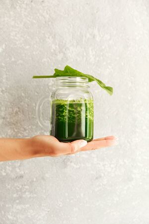 Green smoothie from broccoli, spinach, kiwi and banana on a light background. Eco concept. Healthy green smoothie and ingredients on white - superfoods, detox, diet, health, vegetarian food concept.の写真素材
