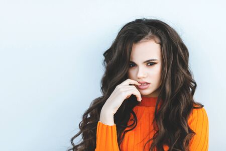 Young teenager on light background. Looking at camera with joyful and charming smile. Amazing teen woman posing at street at autumn outfit, jeans, glam style,teen hipster trend outfit, mood, modelの写真素材