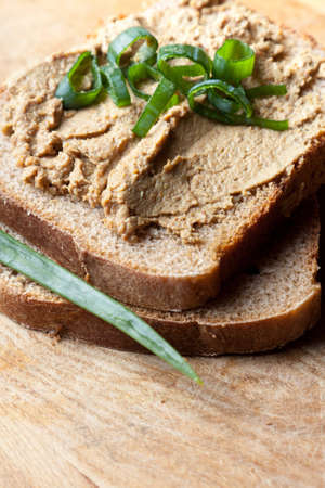 Open sandwich on sliced brown bread with liver pate garnished with fresh herbsの写真素材