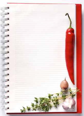 Open blank ringbound notebook surrounded by a fresh vegetables and spice for your shopping or grocery listの写真素材