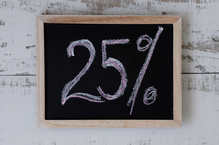 Twenty five percent. Discount and special offer, Price reduction. Blackboard with handwrittent text...