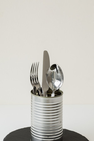 Vertical background with silver tableware in a metal jar. Knife, fork and spoon on white backgroundの写真素材
