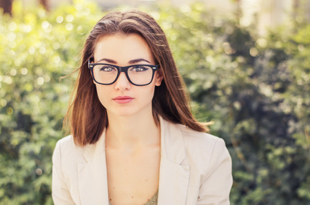 Portrait of a young business woman with short hair, eye glasses and beige jacket. Business look concept. Bob cut hairstyleの写真素材
