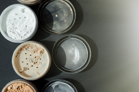 Background with mineral make-up powder for matt foundation of white and beige colors on black surfaceの写真素材