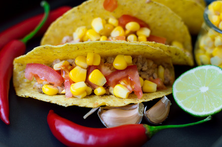 Mexican tacos with chicken mince, tomatoes, corn, garlic, lime and chiliの写真素材
