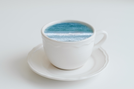 Sea in a coffee cup. Ocean in a mug, creative idea. Coffee break conceptの写真素材