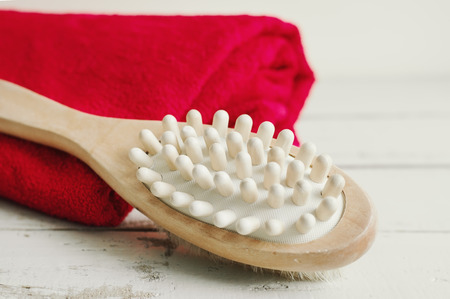 Wooden brush for body massage and red bath towel on wooden background. Body careの写真素材