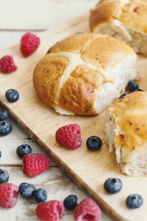 Traditional Easter cross buns with fresh berries. Springtime festive seasonの写真素材