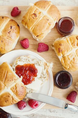 Homemade hot cross buns with butter, jam and raspberry, top view. Traditional Easter pastryの写真素材