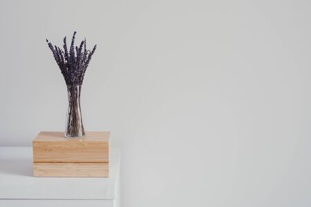 Dried lavender in a small glass vase on wooden jewelry box. Minimalistic style. Home decor. Interior detail. Space for textの写真素材