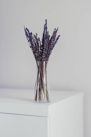 Dried lavender bouquet in a small glass vase. Simple home decor. Minimal scandinavian style interiorの写真素材