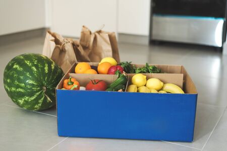 Contactless Grocery delivery. Fresh fruits and vegetables in recyclable paper bags and box. Grocery...