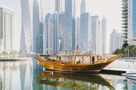 Dubai; UAE - June 6, 2020: Traditional Arabic Dhow boat standing at pier at Dubai Marina, a popular...