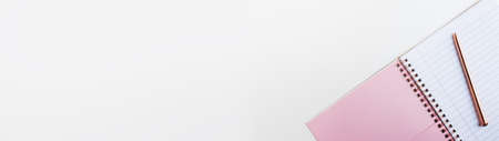 Back to school feminine banner. Pink notebook with clean pages, metal pen on white background, top viewの写真素材