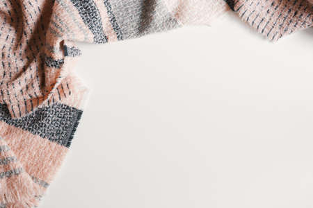 Woolen scarf of pink and gray color on white background, top view, copy space. Fall or winter seasonの写真素材