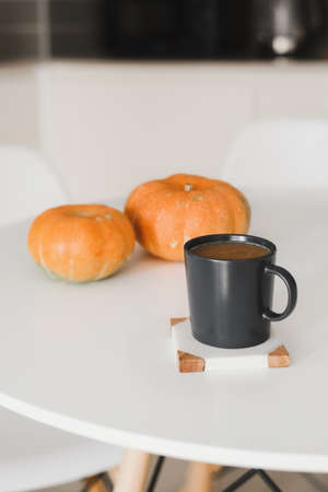Homemade coffee with cinnamon, milk and pumpkin served on a white table. Fall season beverageの写真素材