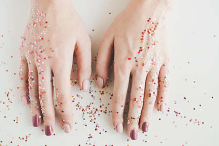 Female's hands with gel manicure and a lot of colorful glitters. Nail art conceptの写真素材