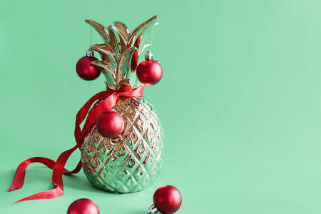 Metal pineapple decorated with red Christmas balls on green background. Alternative Christmas treeの写真素材