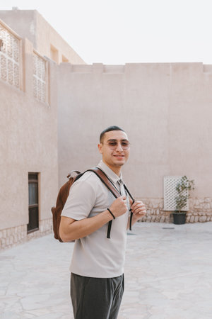 Portrait of a young arab male standing outdoors. Happy male solo traveler captured in Old Dubai while exploring the cityの写真素材